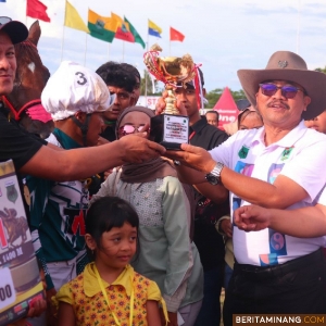 Pj. Wali Kota Payakumbuh Suprayitno, menyerahkan tropi pemenang pada Pacu Kuda Piala Gubernur 2024.di Gelanggang Pacu Kuda Kubu Gadang, Payakumbuh, Minggu (13/10/2024).  Foto : Dok Do