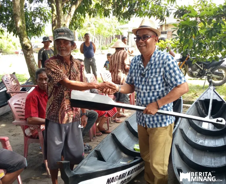 Walinagari  Katiagan  Endang Putra ( Kiri) Menyalurkan Perahu Kepada Salha seorang Nelayan penerimaan Manfaat Program ketahanan Pangan Katiagan. Sabtu, 19/7/2025. Foto : E
