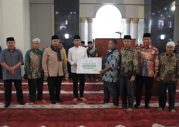Wali Kota, Hendri Arnis dan Wakil Wali Kota, Allex Saputra ketika serahkan secara simbolis Bantuan Program Padang Panjang Cerdas dari Baznas kepada 233 mustahik, di Masjid Agung Manarul 'Ilmi Islamic Centre, Sabtu (26/7/2025). Foto: Kominfo Padang Panjang