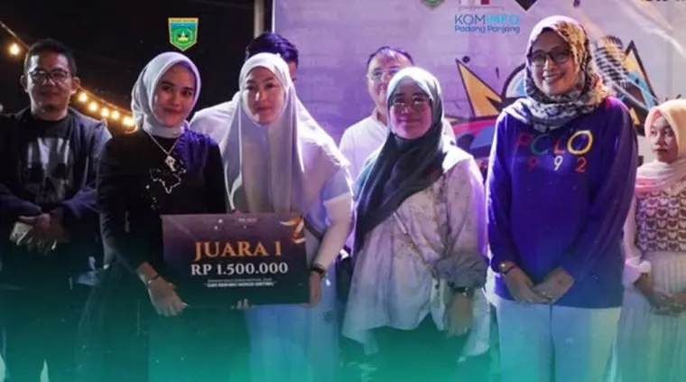 Syifa Rahmadhini menerima hadiah dari Ketua Dekranasda Kota, Ny. Maria Fernonika Hendri sebagai juara pertama Sipappa Solo Song Festival Sabtu (26/7/2025) malam, di Simpang Empat Pasar Pusat Padang Panjang. Foto: Kominfo Padang Panjang