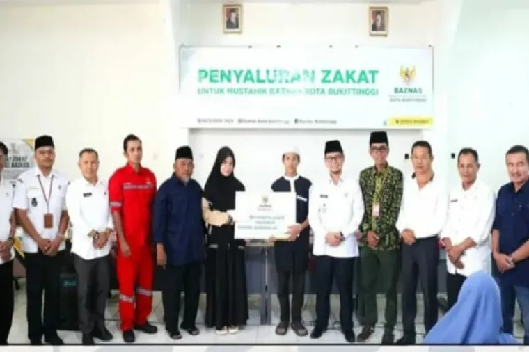 Wawako Ibnu Asis bersama BAZNAS Bukittinggi menyerahkan secara simbolis bantuan program pendistribusian zakat untuk mustahiq di aula kantor BAZNAS, Rabu, (9/7).