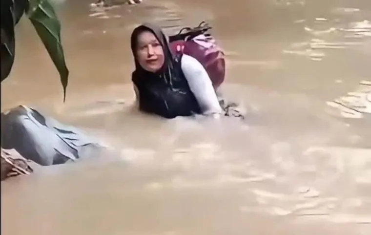 Dona Lubis (46) dari Pasaman, Sumatera Barat, viral di media sosial saat seberangi sungai. Foto: Adpim Sumbar