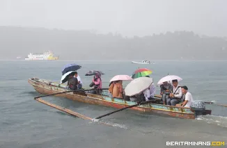Hujan-hujan pelajar melintas di depan kapal ASDP yang memasuki selat Pagai, Kabupaten Kepulauan Mentawai, Sumbar,  Senin (19/8/2025). (Beritaminang/Adi Prima)