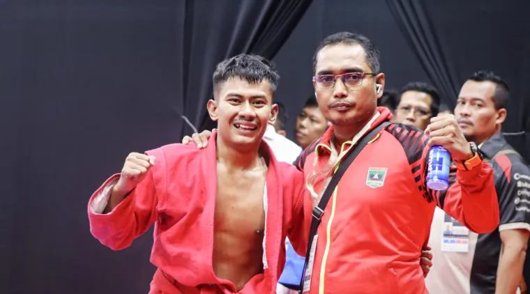 Pelatih Sambo Sumbar Hendri Gusman Darma bersama peraih emas pertama Sambo di PON Beladiri, Yusril Mahendra. Foto: dok. Humas KONI Sumbar