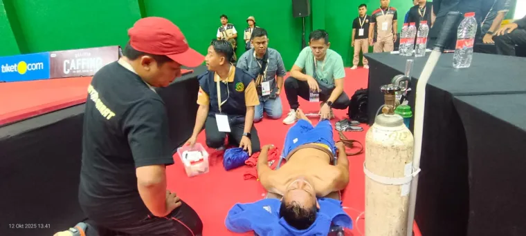 Ketua KONI Sumbar Hamdanus ketika melihat Farid  yang sempat mendapatkan perawatan medis akibat cedera ringan yang dialaminya saat bertanding, Minggu (12/10/2025). Foto: Humas KONI Sumbar
