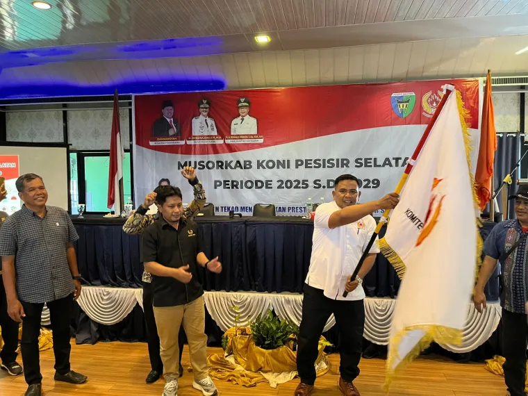 Muhammad Adli kibarkan bendera ketika terpilih sebagai Ketua Umum KONI Pessel 2025-2029 dalam sidang pleno yang dilaksanakan, di Saga Murni Hotel, Sabtu (1/10/2025). Foto: Humas KONI Sumbar