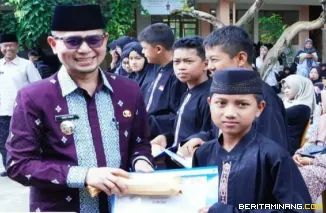 Wawako Ibnu Asis menyerahkan reward kepada pelajar SMPN 3 Bukittinggi yang mempunyai saldo tabungan haji terbanyak, di halaman sekolah itu jumat, (13/03).