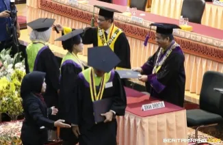 Rektor UNP Ir. Krismadinata, Ph.D saat memindahkan jambul wisudawan dan Dekan Fakultas Bahasa dan Seni Prof. Ermanto memberikan ijazah wisudawan, Selasa (30/6/2026). (Foto: Huswatun Hasanah/ Kantor Komunikasi dan Pemasaran Strategis)