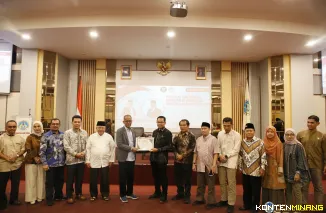 Wakil Ketua Mahkamah Konstitusi Republik Indonesia, Prof. Dr. Saldi Isra, S.H., M.P.A., ketika menerima cindera mata dari Rektor UNP, Krismadinata, Ph.D, Jumat (11/7/2027). Foto: Humas UNP